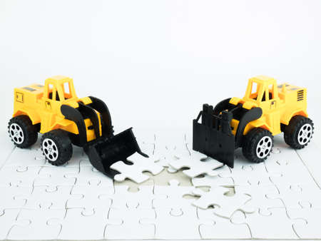 Toy bulldozer and forklift with Jigsaw puzzle on white background.の写真素材