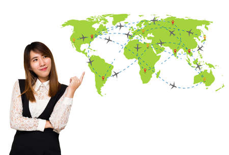 Young Asian business woman smile and point up to Plane routes over world map isolated on white background, Travel by airplane concept.の写真素材
