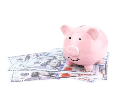 Pink piggy bank on dollars banknote isolated on white background, saving concept.の写真素材
