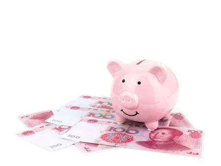 Pink piggy bank on chinese banknote isolated on white background, saving concept.の写真素材
