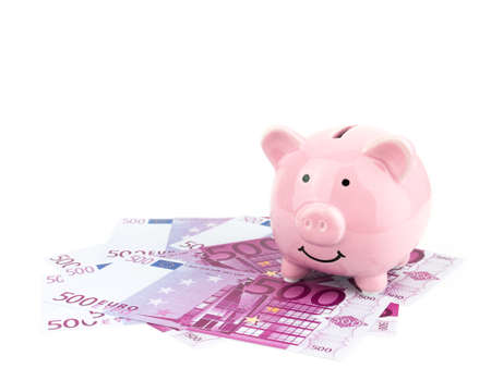 Pink piggy bank on Euro banknote isolated on white background, saving concept.の写真素材