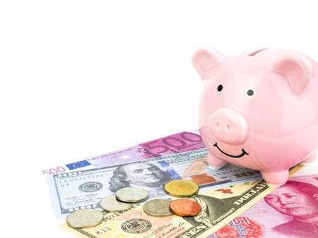 Pink piggy bank on dollars, chinese, euro banknote isolated on white background, saving concept.の写真素材