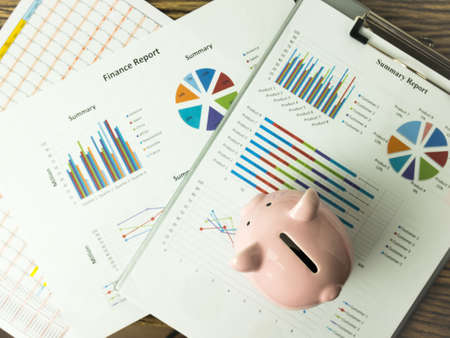 Pink piggy bank on business graph, finances and economy concept.の写真素材