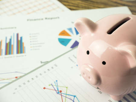Pink piggy bank on business graph, finances and economy concept.の写真素材