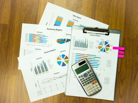 Business report chart and Financial graph analysis with calculator on table.の写真素材