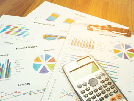 Business report chart and Financial graph analysis with calculator on table.の写真素材