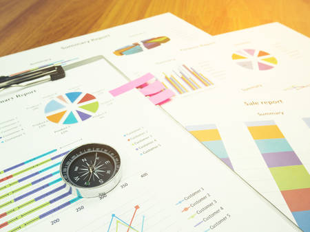 Business report chart and Financial graph analysis with compass on table.の写真素材