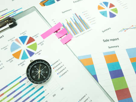 Business report chart and Financial graph analysis with compass on table.の写真素材