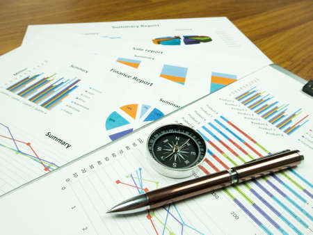 Business report chart and Financial graph analysis with pen and compass on table.の写真素材