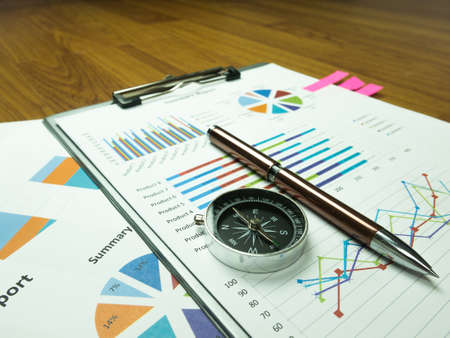 Business report chart and Financial graph analysis with pen and compass on table.の写真素材