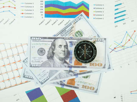 Business report chart and Financial graph analysis with dollar money and compass on table.の写真素材