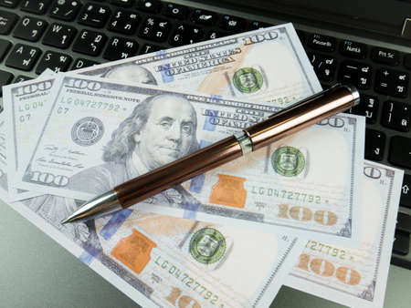 Business report chart and Financial graph analysis with dollar money and pen on the table.の写真素材