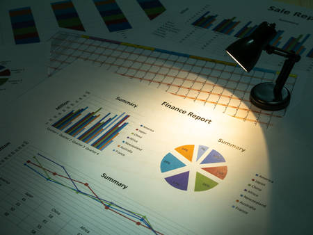 Business finance report with light lamp on wooden table background.の写真素材