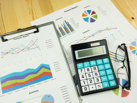 Business marketing graph and Financial analysis chart report  with calculator on wooden table background.の写真素材