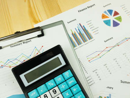 Business marketing graph and Financial analysis chart report  with calculator on wooden table background.の写真素材