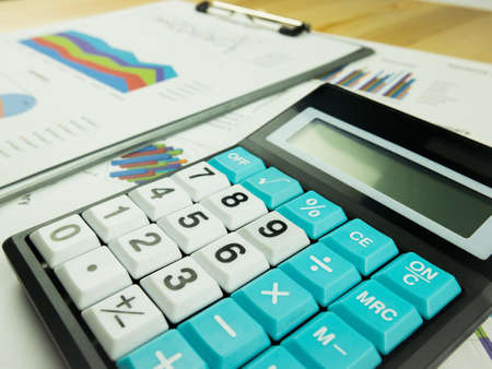 Business marketing graph and Financial analysis chart report  with calculator on wooden table background.の写真素材