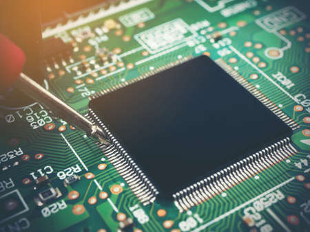 Closeup of checking electronic PCB (Printed circuit board) with microchips processor technology.の写真素材