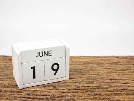June 19 white cube wooden calendar on vintage wood and white background with Summer day, Copyspace for text.の写真素材