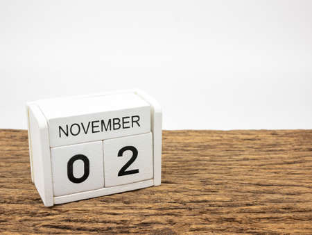 November 2 white cube wooden calendar on vintage wood and white background with autumn day, Copyspace for text.の写真素材