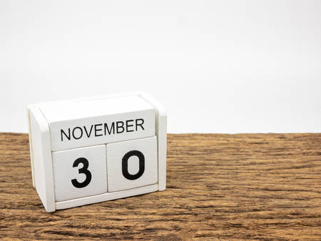 November 30 white cube wooden calendar on vintage wood and white background with autumn day, Copyspace for text.の写真素材