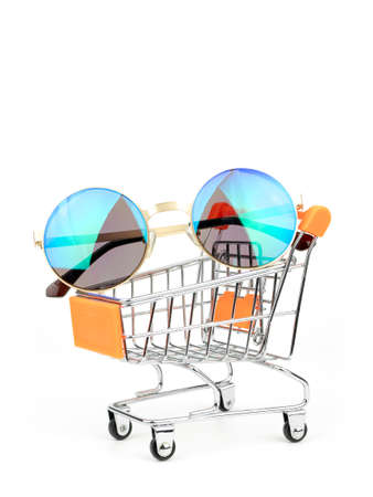 Sunglasses in a Shopping cart, Push Cart isolated on white background. Fashion consumptiont concept.の写真素材