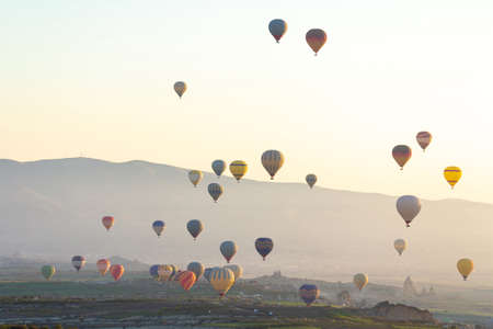 Colorful Hot air balloon flying over Red valley at Cappadocia, Anatolia, Turkey. Volcanic mountains in Goreme national park.の写真素材