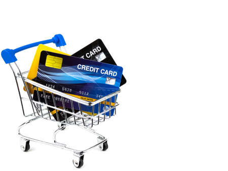 Credit cards in small shopping cart isolated on white background.の写真素材