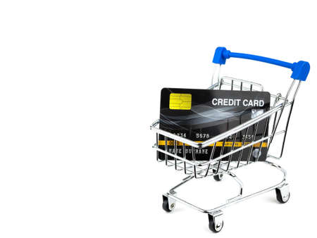 Credit cards in small shopping cart isolated on white background.の写真素材