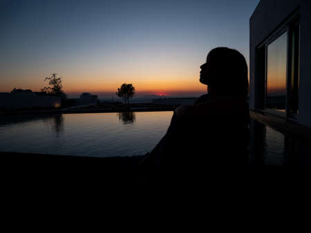 Sad woman silhouette worried at sea and sunset.の写真素材