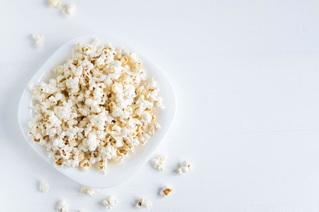 Background with a plate of popcorn. White background with popcorn.の写真素材