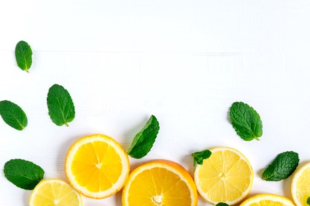 White background with lemon, orange slices and mint. Concept with fresh fruit. Lemon, Orange, Mint. View from above.の写真素材