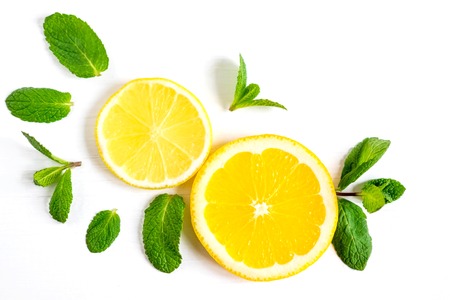 White background with lemon, orange slices and mint. Concept with fresh fruit. Lemon, Orange, Mint.
