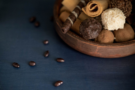 Photo of chocolate candies and waffles on a blue background with a place for copispeys. Photos of chocolates and sweets. Frame for a card with sweetsの写真素材