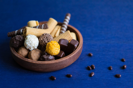 Preparation for a banner with sweets. Photo of chocolate candies and waffles on a blue background with a place for copispeys. Photos of chocolates and sweets.の写真素材