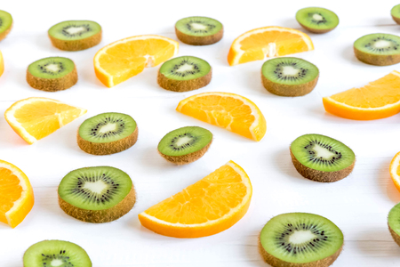 Pattern with oranges and kiwi slices on a white wooden background. The basis for the booklet, the background for the banner.の写真素材