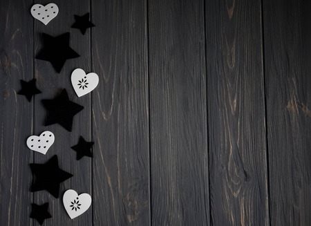 Stars of black color and white hearts on a white wooden background. Background for teens with starsの写真素材