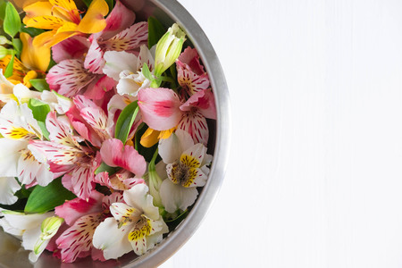 Frame for the text of congratulations with natural flowers of Alstroemeria on a wooden background. Design greeting card with natural colors. Background for text with alstromeria.の写真素材