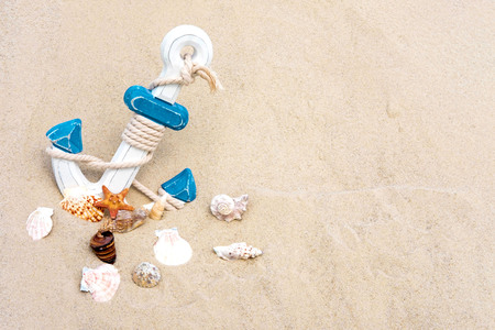 Sea background with anchor and seashells. Anchor in the sand. Frame for text tourist, travel banner...