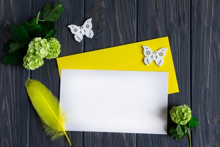 Letter template for greeting inscription with yellow-green flowers on gray wooden background. Frame for greeting banner, postcard.の写真素材