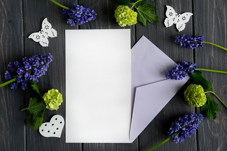 Letter template for greeting inscription with yellow-green and purple flowers on gray wooden...