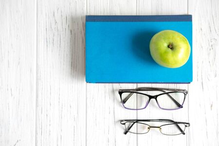 Photo with books and glasses on a wooden background with a place for copispeys. Frame for text banner on the subject of accounting, study and training.の写真素材