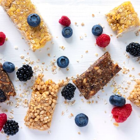 Pattern with cereal bars and blueberries, blackberries and raspberries with oatmeal. Healthy snacksの写真素材