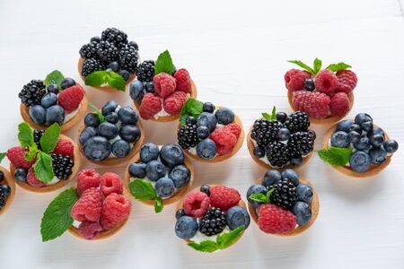 Tartlets with soft cheese and berries of raspberry, blackberry, blueberry. Delicious and healthy desserts.の写真素材
