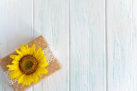 Greeting card with flowers of sunflower and box with gift on wooden background. Autumn banner with sub-sunflowers. Frame for text with flowersの写真素材