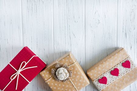 Three gifts close up on a light wooden background with a place for copy space. Frame for text with boxes of presents. Background for sale banner, discount, discounts.の写真素材