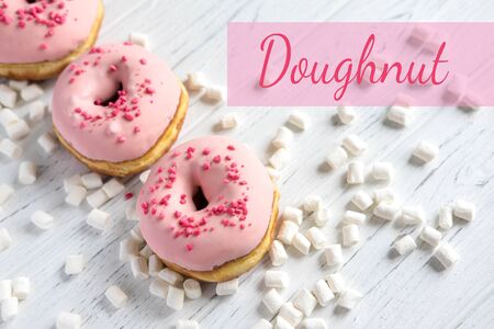 Photo with donuts and marshmallows on a wooden background. Sweets on a dark background. Pink donutsの写真素材