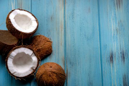 Coconut chopped half on a wooden background of blue tseta. Tropical background with place for copy space.の写真素材