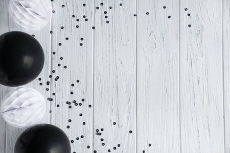 Wooden background with paper party decorations and balloons. Frame for greeting card, invitation to a party, wedding. View from aboveの写真素材