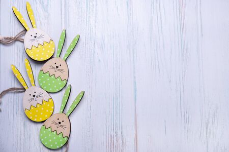 Wooden background for an Easter card with a rabbit and eggs with place for copy spaceの写真素材