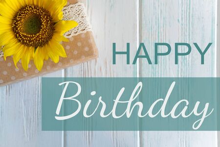 Birthday card with gift and flower of a sunflower. Happy birthday letteringの写真素材